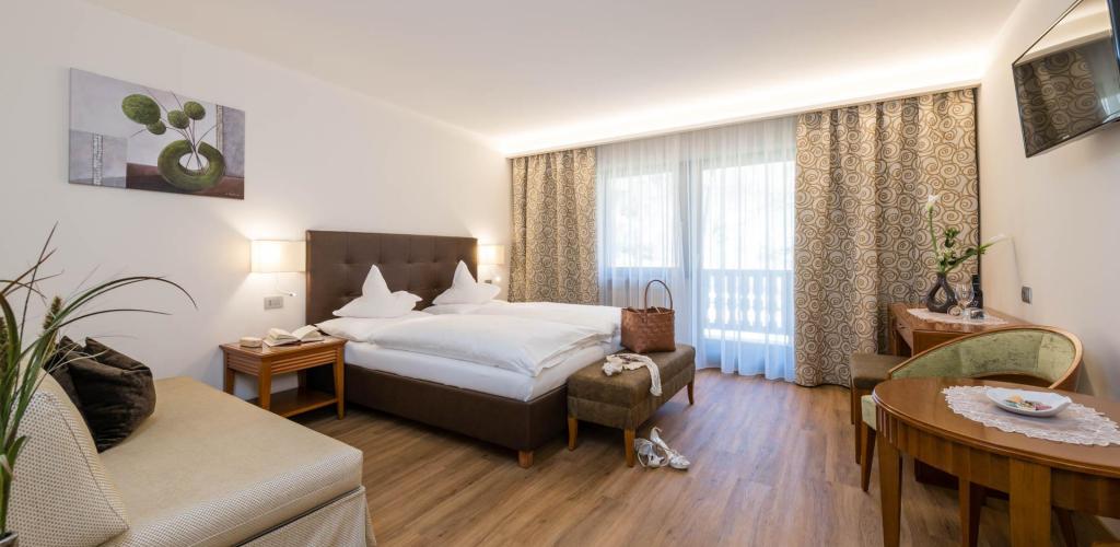 Superior Room with wooden floor, double bed, balcony, and TV