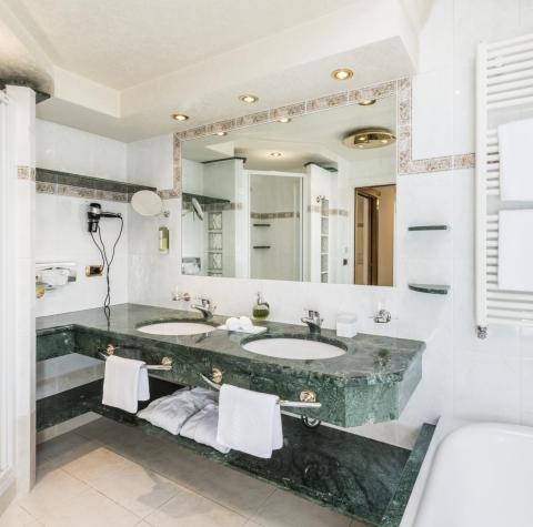 The marble bathroom with two washnbasns, a shower and a bathtub of the Rose Suite