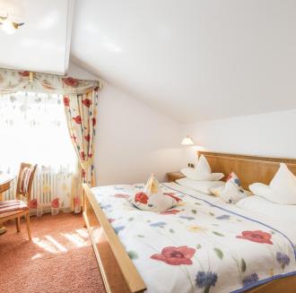 A bedroom with a double bed of the Poppy Suite