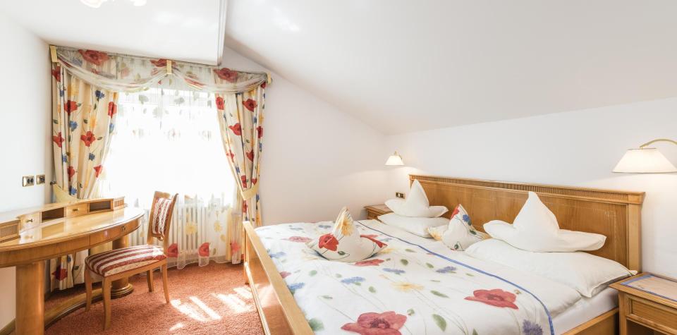 Ein Schlafzimmer mit Doppelbett in der Mohnblumensuite