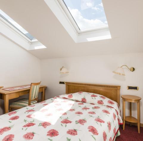 A bedroom with a single bed in the Rose Suite